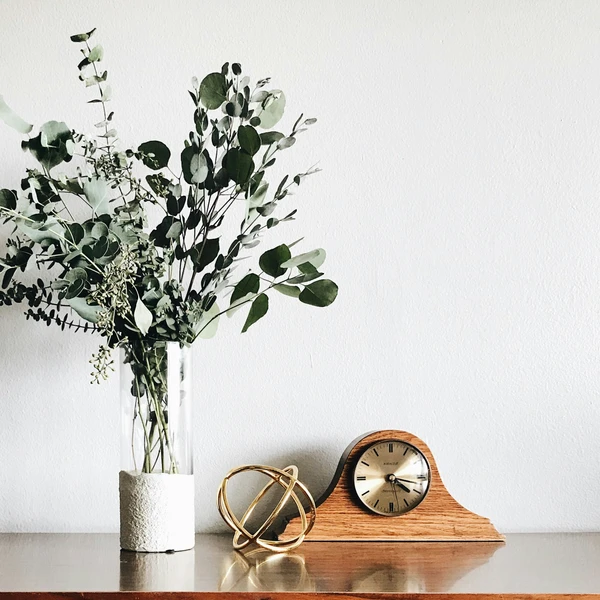 Vintage clock and decor items on wooden surface